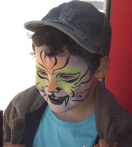Criança feliz depois de ter a sua pintura facial concluída. 